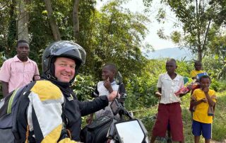 Motorcyclists and local children in Africa
