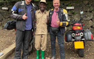 Two motorcyclists with locals in Africa